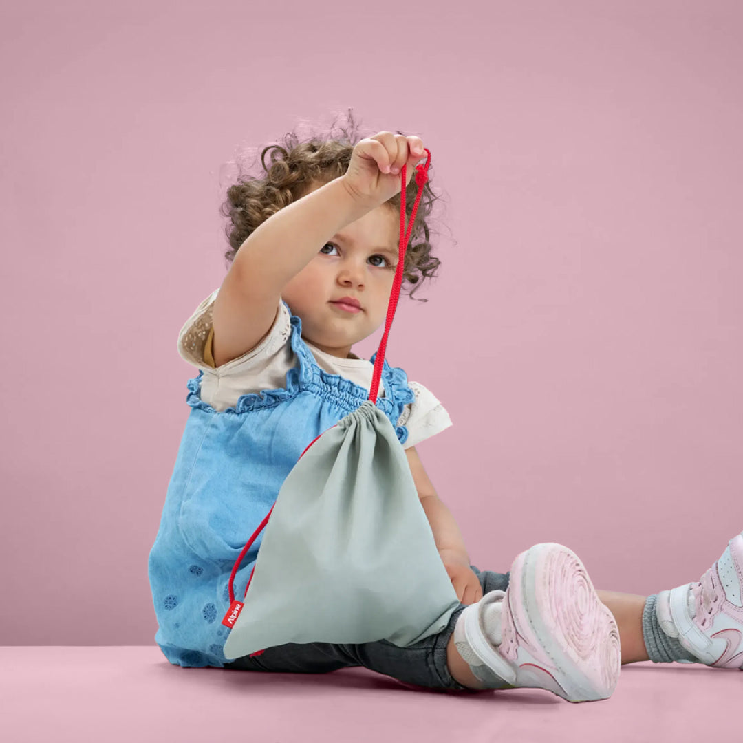 Toddler holding Alpine Muffy Baby storage bag 