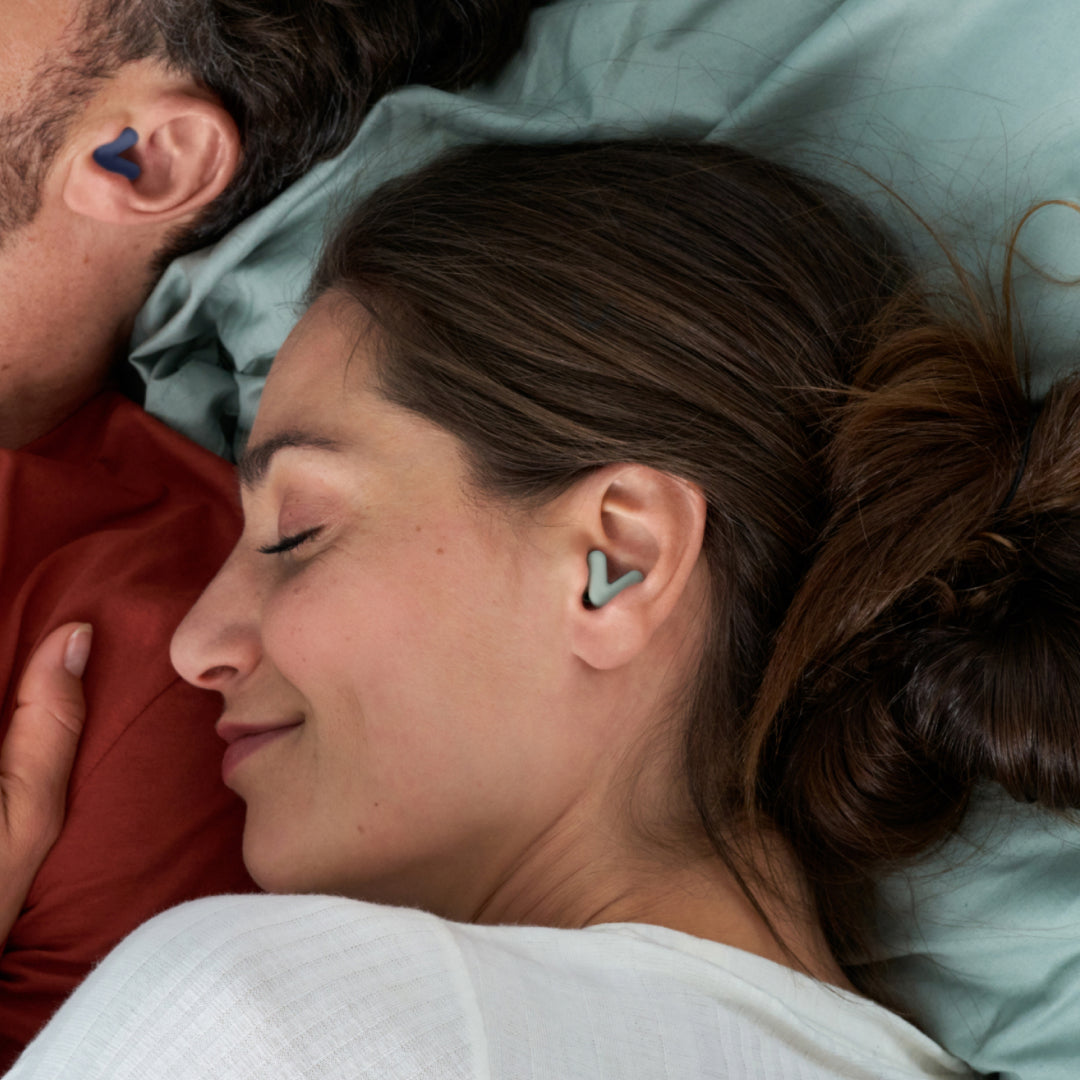 Man and woman sleeping, wearing Alpine Silence earplugs in green that stay securely in place 